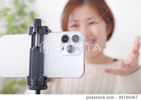 A woman talking to a fixed smartphone A woman talking to a fixed smartphone 98780067