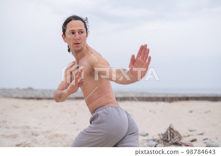 Caucasian man practices martial arts outdoors. balance and meditation. Caucasian man practices martial arts outdoors. balance and meditation. 98784643