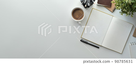 Top view of blank notebook, cup of coffee, pencil holder and houseplant on white table. Copy space for your text Top view of blank notebook, cup of coffee, pencil holder and houseplant on white table. Copy space for your text 98785631