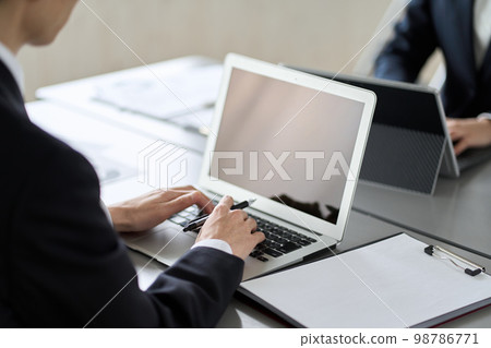 A business person who operates a laptop for desk work 98786771