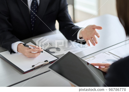 Asian business person showing and explaining a tablet 98786778