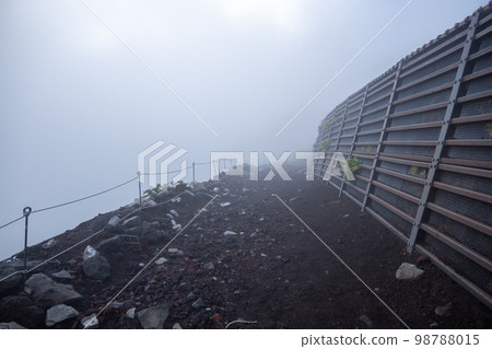 Mt Fuji trail on Fujiyoshida route in a dense fog in Fujiyoshida, Yamanashi, Japan. August 4, 2022 Mt Fuji trail on Fujiyoshida route in a dense fog in Fujiyoshida, Yamanashi, Japan. August 4, 2022 98788015