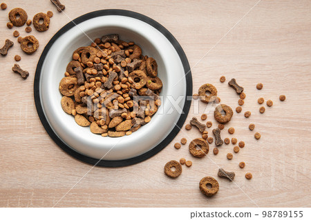 A bowl of dog food on a wooden floor. A bowl of dog food on a wooden floor. 98789155