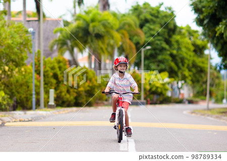 Child riding bike. Kid on bicycle in sunny park. Child riding bike. Kid on bicycle in sunny park. 98789334