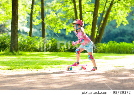 Child riding skateboard in summer park Child riding skateboard in summer park 98789372