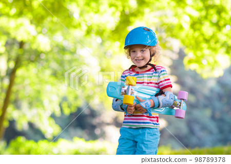 Child riding skateboard in summer park Child riding skateboard in summer park 98789378
