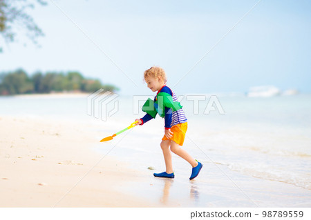 Kids play on tropical beach. Sand and water toy. Kids play on tropical beach. Sand and water toy. 98789559