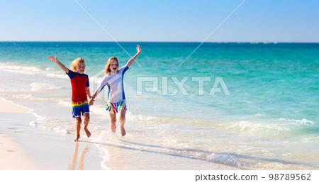 Kids playing on beach. Children play at sea. 98789562
