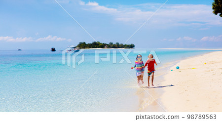 Kids play on tropical beach. Sand and water toy. 98789563