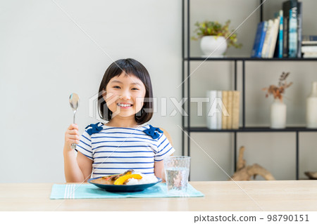 Elementary school girl eating curry 98790151