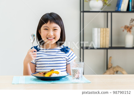 Elementary school girl eating curry 98790152