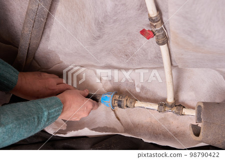 Insulating water supply pipes in basement of rural house on eve of winter frosts. Insulating water supply pipes in basement of rural house on eve of winter frosts. 98790422