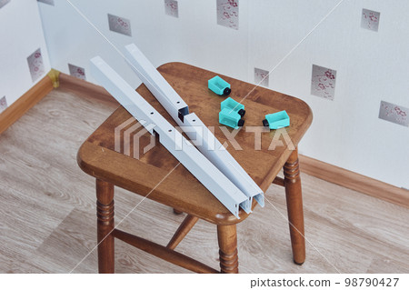 Components of new floor standing fan are prepared for installation. 98790427