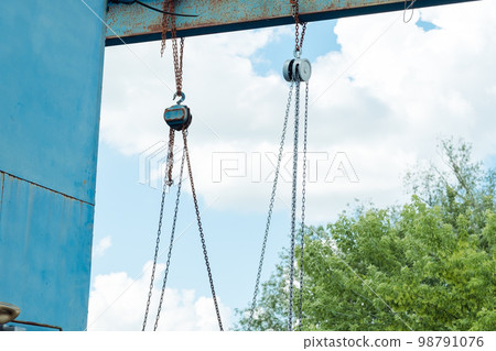 old iron structure with hook chains on the street old iron structure with hook chains on the street 98791076