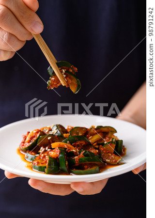 Kimchi cucumber holding by hand ready to eating, Korean food side dish 98791242