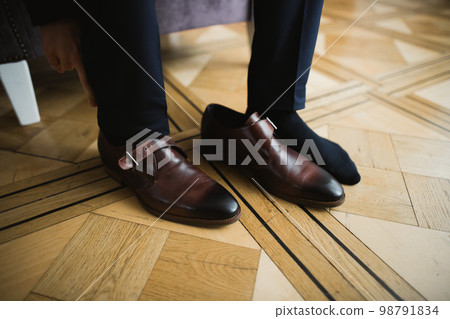Grooms morning preparation. Handsome man getting dressed and preparing for the wedding 98791834