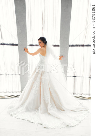 Luxury bride in white dress posing while preparing for the wedding ceremony Luxury bride in white dress posing while preparing for the wedding ceremony 98791861