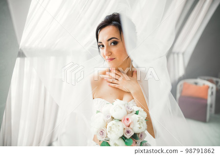 Portrait of stunning bride with long hair posing with great bouquet Portrait of stunning bride with long hair posing with great bouquet 98791862