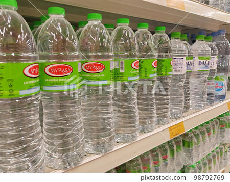KUALA LUMPUR, MALAYSIA -MAY 1, 2022: Mineral water is packaged in plastic bottles and labeled with various brands. Displayed on a shelf inside a supermarket. Placed with a price tag 98792769