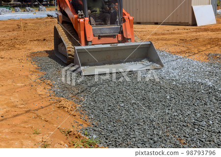 There is bucket full of crushed stone being loaded into an excavator as it hauls full bucket gravel into 98793796