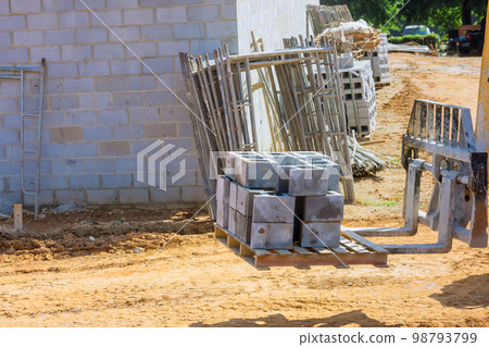 Boom truck forklift moving cement blocks to place where wall of house is going to be installed 98793799