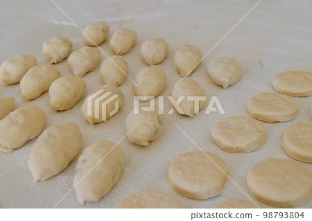 Preparation to baking bun with stuffing and donuts from yeast dough Preparation to baking bun with stuffing and donuts from yeast dough 98793804