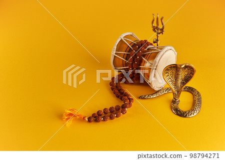 Shivaratri background with Shivas trident, Pellet Drum Damroo musical instrument ans snake . Maha Shivratri festval 98794271