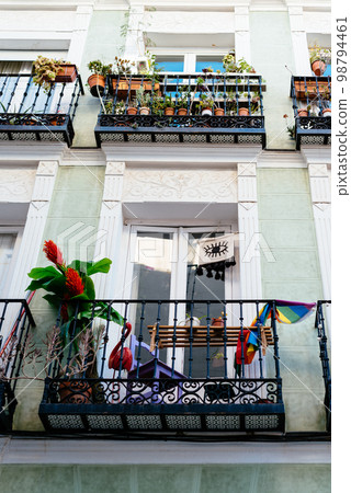 Traditional iron balcony with pots hanging from the railing 98794461