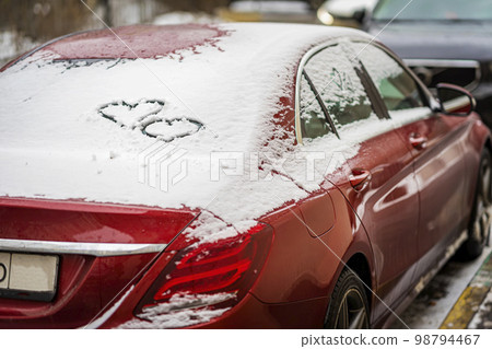 Hearts hand-drawn on car's window on background of snow. Concept of love, romance, Valentine's Day Hearts hand-drawn on car's window on background of snow. Concept of love, romance, Valentine's Day 98794467