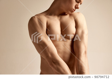 Young male model posing in underwear. Cropped image of muscular relief body, breast over grey studio background. Men's health, beauty and sportive lifestyle 98794712