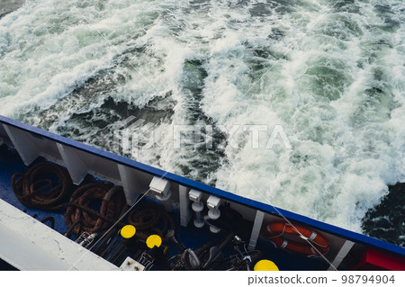 Wake of vessel. Wide wake trail from boat. Ocean water. Deep blue. Trace from large ship. Sunset rays on water from luxury sail yacht. Ship Sailing on Sea. Waves from the back of speed boat over the Wake of vessel. Wide wake trail from boat. Ocean water. Deep blue. Trace from large ship. Sunset rays on water from luxury sail yacht. Ship Sailing on Sea. Waves from the back of speed boat over the 98794904