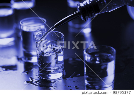 Vodka is poured into shots at the bar 98795377