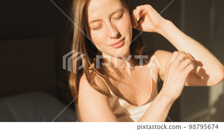 Portrait woman waking up in her bed, she is smiling and stretching. Happy young woman greets new sunny day Portrait woman waking up in her bed, she is smiling and stretching. Happy young woman greets new sunny day 98795674