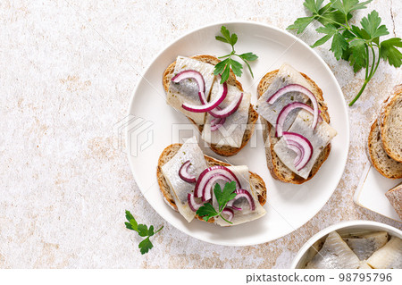 Herring sandwich. Open sandwiches with whole grain bread, herring and onion. Top view 98795796
