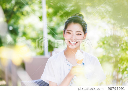 Young girl eating soft serve ice cream with a smile 98795991