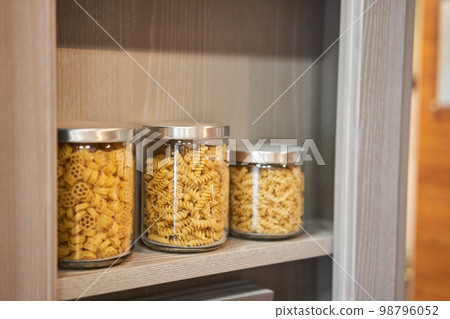 Various uncooked cereals, grains, beans and pasta for healthy cooking in glass jars. Clean eating, vegan, balanced dieting food concept 98796052