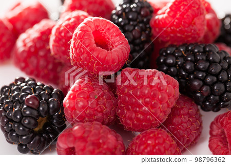 handful of raspberry and blackberry berries on white background 98796362