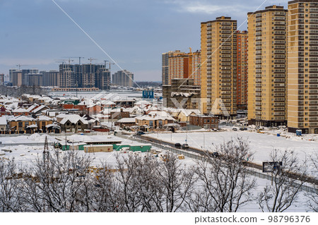 Winter urban landscape. New Residential buildings, snow covered land and privat houses Winter urban landscape. New Residential buildings, snow covered land and privat houses 98796376