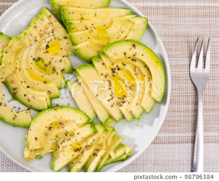 ripe avocado pulp cut into pieces sprinkled with lemon juice on a plate 98796384