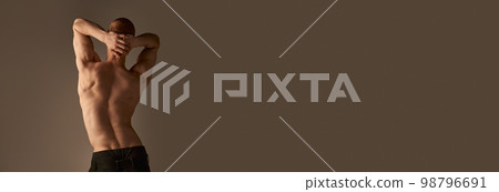 Back view photo of shirtless young man in pants over grey studio background. Strong, relief, muscular body, back. Men's health, beauty and sportive lifestyle 98796691