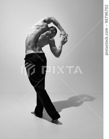 Relief. Black and white photography. Masculinity aesthetics. Young man posing shirtless. Muscular body shape. Men's health, beauty and sportive lifestyle Relief. Black and white photography. Masculinity aesthetics. Young man posing shirtless. Muscular body shape. Men's health, beauty and sportive lifestyle 98796702