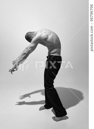 Round back. Black and white photography. Masculinity aesthetics. Young man posing shirtless. Muscular body shape. Men's health, beauty and sportive lifestyle 98796706