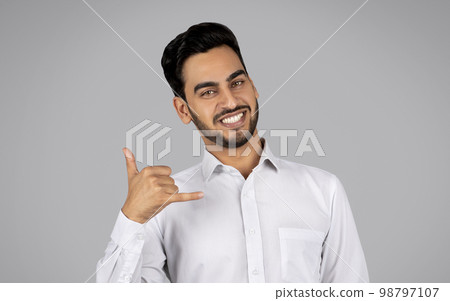 Call Me. Smiling Arab Businessman Making Phone Gesture And Looking At Camera Call Me. Smiling Arab Businessman Making Phone Gesture And Looking At Camera 98797107