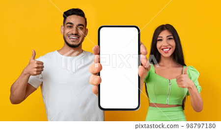 Mobile Mockup. Middle Eastern Couple Demonstrating Blank Smartphone And Showing Thumbs Up 98797180