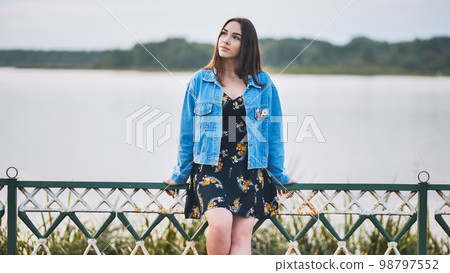 Portrait of a lonely girl by a lake. Portrait of a lonely girl by a lake. 98797552