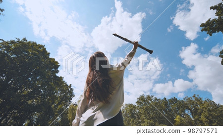 The inspired girl musician lifts the clarinet up against the blue sky. The inspired girl musician lifts the clarinet up against the blue sky. 98797571