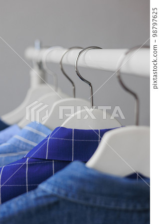 hangers with clothes, wardrobe shirt jacket blue. storing clothes or shopping. hangers with clothes, wardrobe shirt jacket blue. storing clothes or shopping. 98797625
