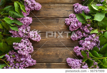 Blooming lilac flowers lie on a wooden background Blooming lilac flowers lie on a wooden background 98797999