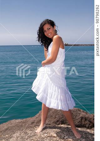 young woman on the beach enjoying the good weather near the sea 98798262