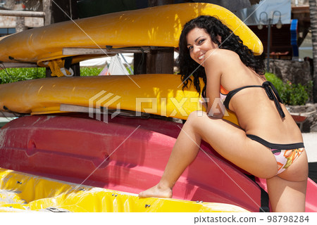 young woman on the beach near some canoes young woman on the beach near some canoes 98798284